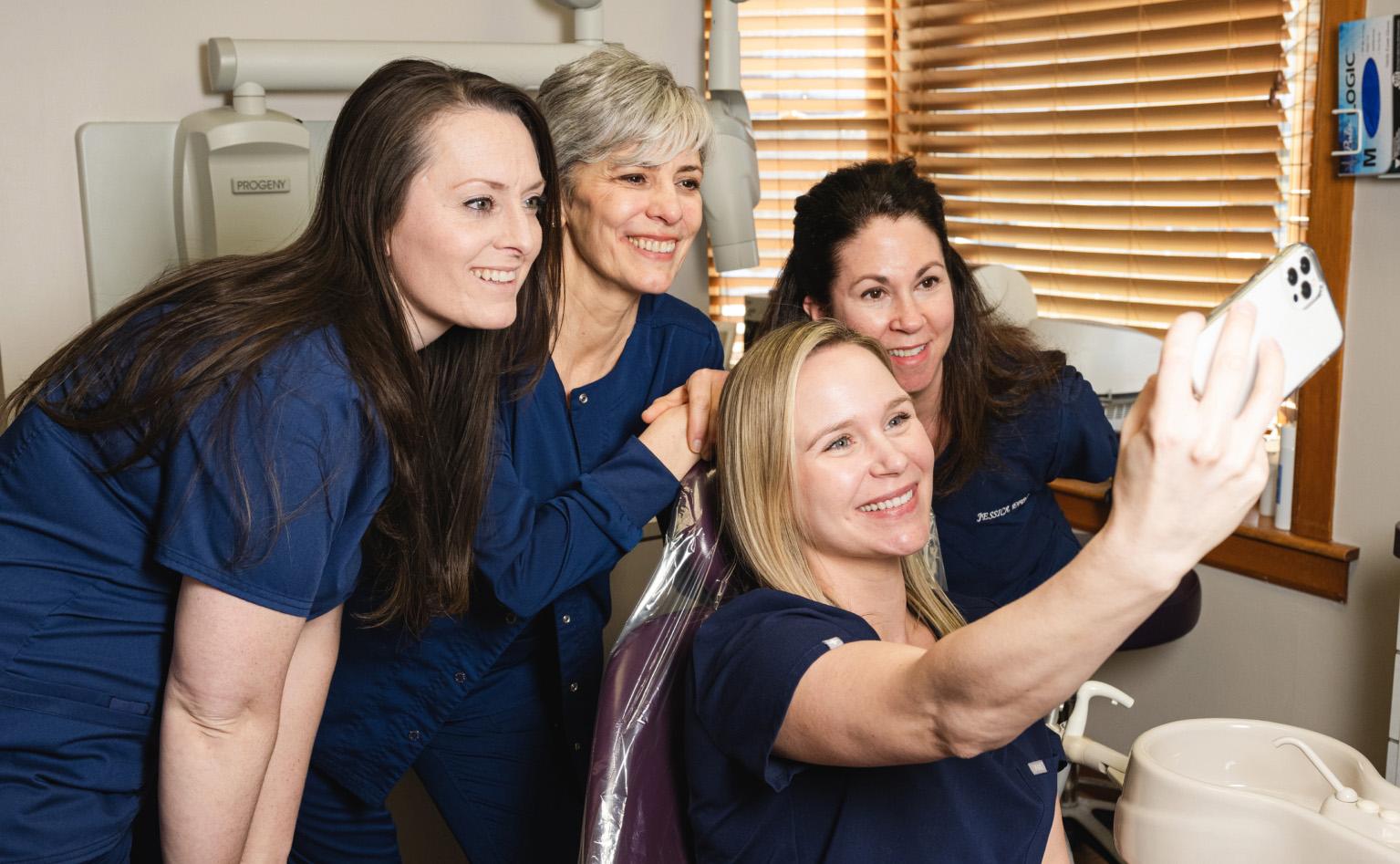 Four women that work in the office taking a selfie